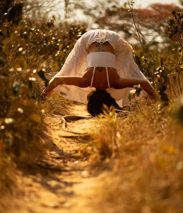 Woman in a graceful yoga pose with warm amber lighting accents.